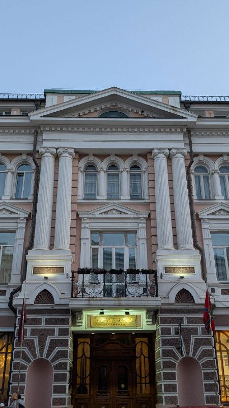Фасад исторического здания во Владивостоке: классические колонны и богатая отделка в европейском стиле, снимок сделан крупным планом.