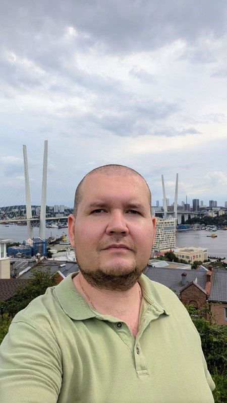 Портретное селфи автора на фоне городского вида и вантового моста — сочетание человеческого плана и архитектурного ландшафта Владивостока.