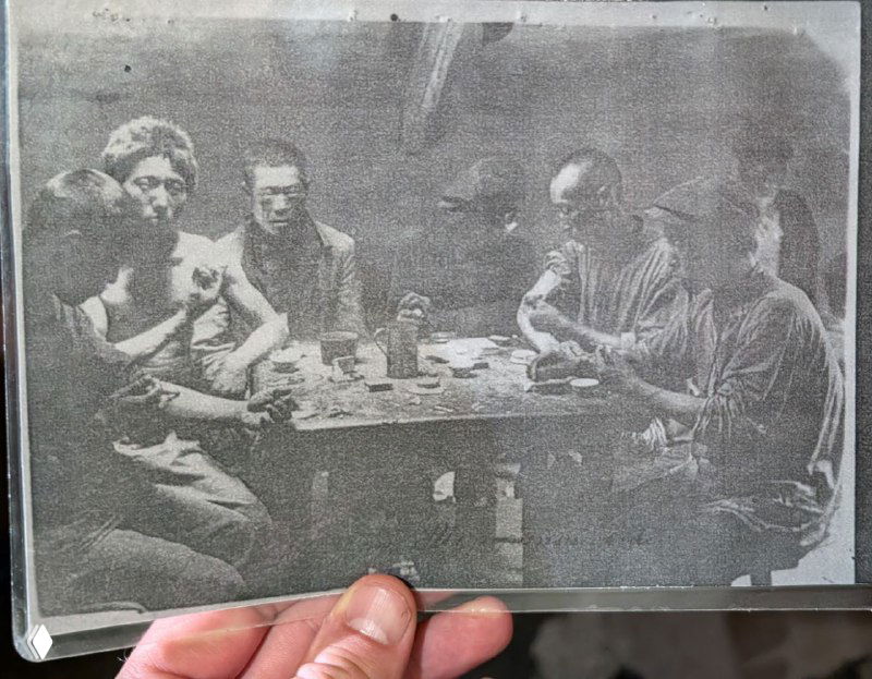 Чёрно‑белая старая фотография людей за столом — исторический снимок, иллюстрирующий бытовую жизнь в дворах Миллионки в прошлом.