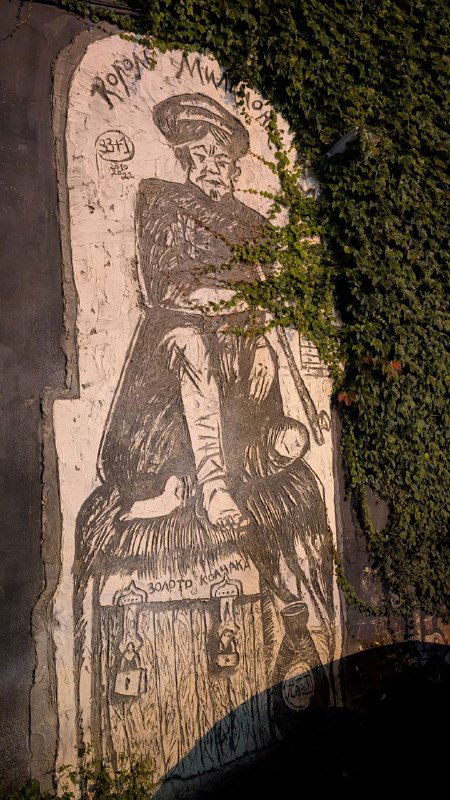 Настенная графика или фрагмент росписи на стене дома во дворе Миллионки — уличное искусство и сюжетный портрет в городской среде.
