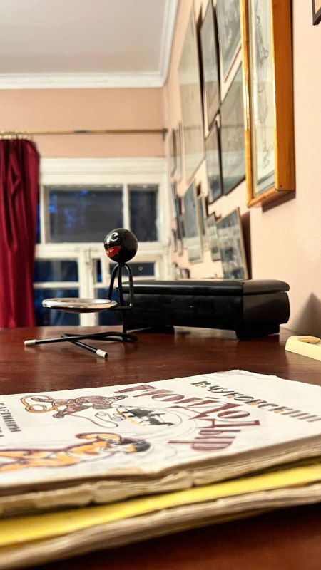 Крупный план бумаг, печатных изданий и старинного проигрывателя в экспозиции — архивные материалы и предметы быта литературной эпохи Чуковского.