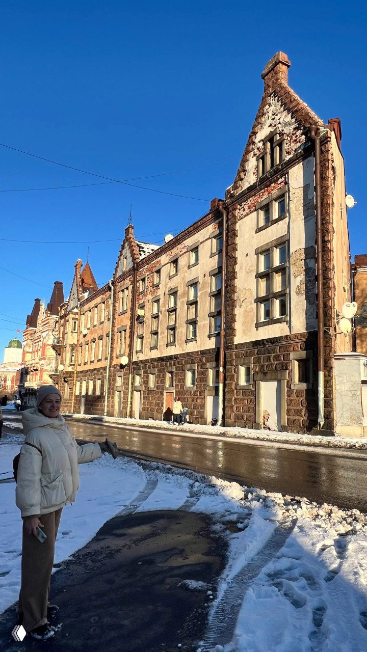 Широкий кадр спокойного залива и лесной линии на горизонте; ясное небо и зеркальная поверхность воды создают умиротворённую сцену.