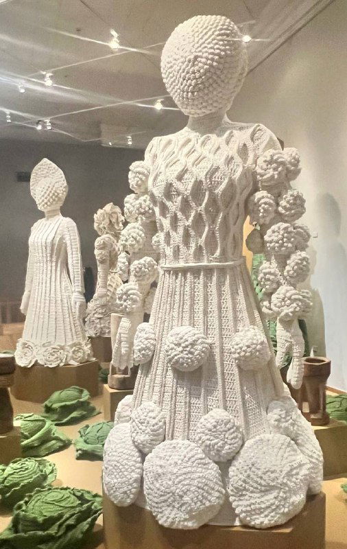 Сцена с сервировкой и фигурами в традиционных нарядах — капустный сад и отсылки к фольклорным мотивам в оформлении стола.