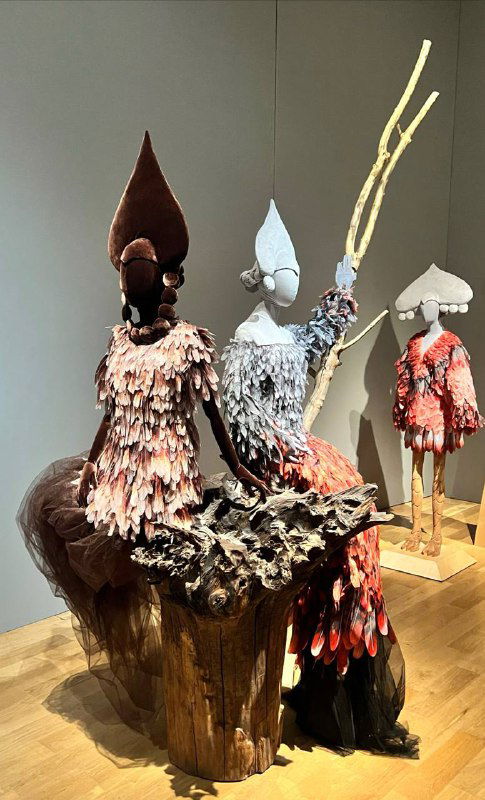 Тонкая текстильная работа: несколько манекенов в голубых платьях с подробной мелкой фактурой и струящейся отделкой пола и корсета.