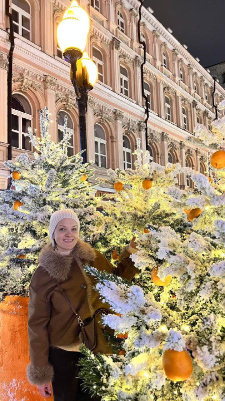 Улица со снежно-украшенными еликами и исторической архитектурой на фоне — одна из пешеходных зон старого центра Москвы, оформленная к Новому году.