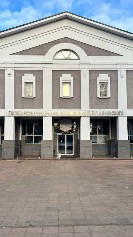 Фасад дома-музея Чайковского с колоннами и центральным входом на пустой площади в ясный день; наружный вид исторического здания, сделано в репортаже.