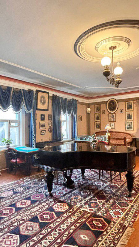 Интерьер музыкальной гостиной музея с роялем, ковром и старинной обстановкой XIX века; атмосфера домашнего салона у композитора.