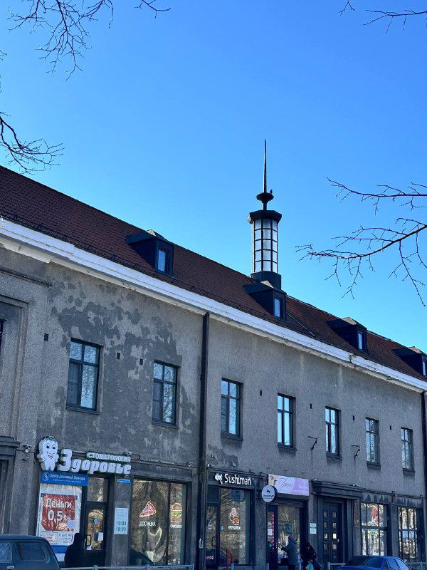 Городской дом с неотреставрированными фасадами и вывесками небольших магазинов — типичная улица Сортавалы с местной жизнью.