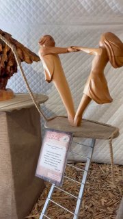 Деревянные фигурки в экспозиции: сцена с отцом и ребёнком, гладкая отделка и динамичная поза, выставочный контекст с информационной табличкой.