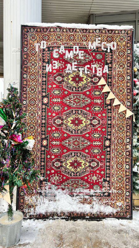 Невысокий настенный ковер как фотозона с новогодним декором и снегом у основания, уличная праздничная инсталляция в Рязани.