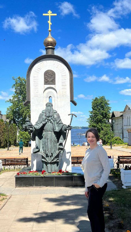 Памятник и часовня на набережной Калязина: мемориальный комплекс на фоне купеческих домов и зелени в летний день.