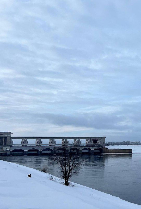 Плотина на Волге в Угличе, холодная река и берег в снегу; архитектура гидроузла заметна на фоне равнины.