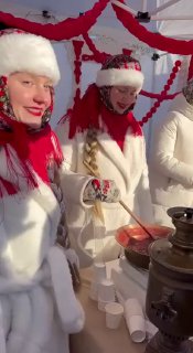 Момент с уличного павильона: одетые в белое участницы раздают угощения, декор в красно-белых тонах и праздничная сценография.