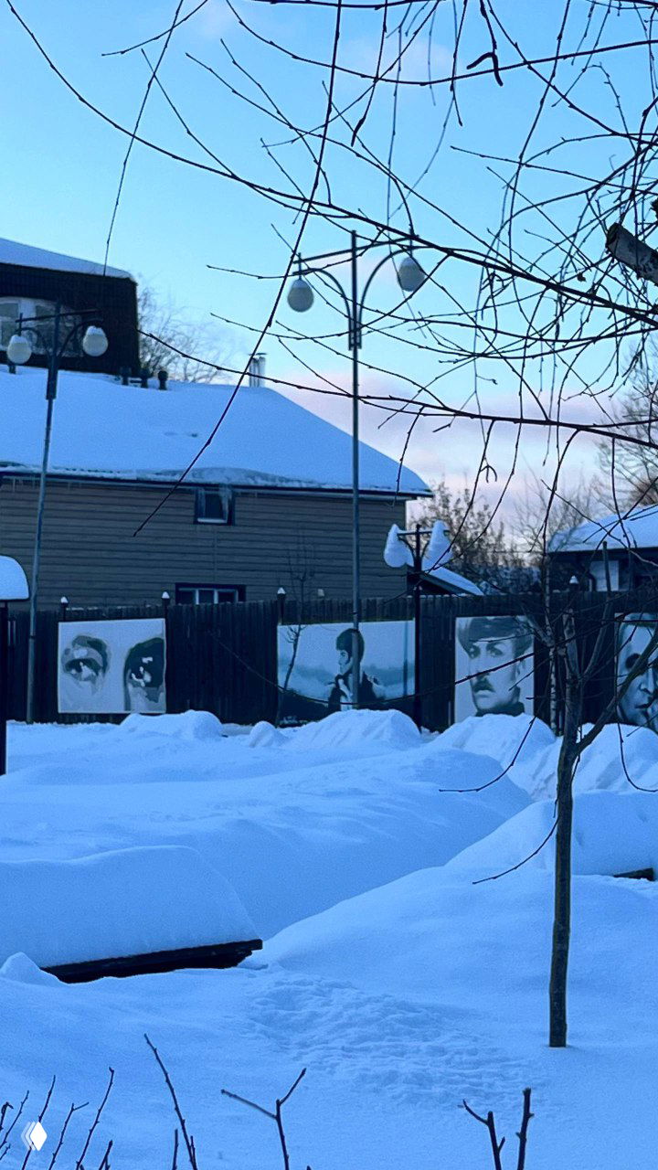 Зимний двор музея: короткие прогулочные маршруты и уличные стенды с изображениями из жизни и фильмов Тихонова, заснеженная территория и ограждения с экспозициями.