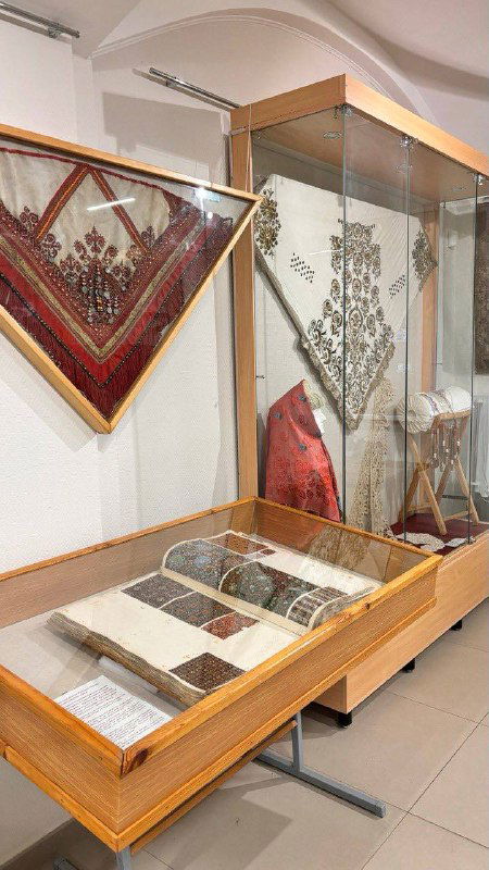 Экспозиция музея платка: витрина с образцами тканей, архивными материалами и текстовыми описаниями истории производства платков на мануфактуре.