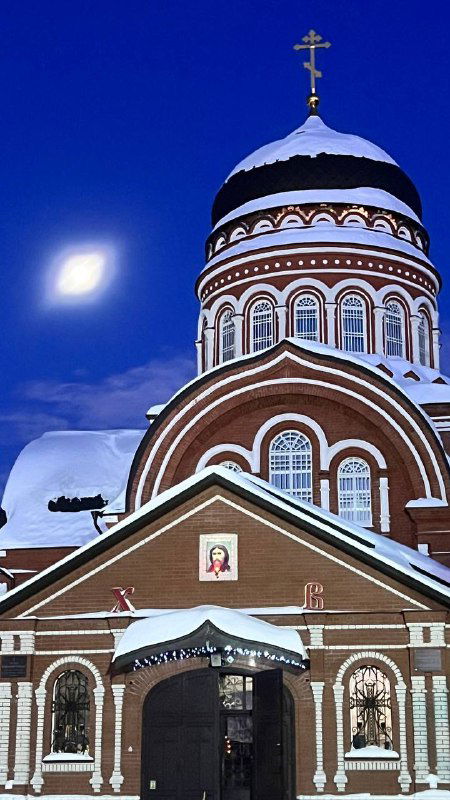 Купол и фасад Храма Вознесения на фоне глубокого синего неба вечером; архитектурные детали и снежные карнизы видны крупным планом.