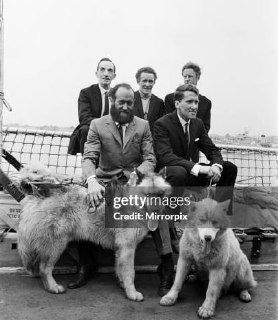 Команда полярников с ездовыми собаками на палубе корабля — чёрно‑белая фотография подготовки к пешим походам по ледяным просторам Арктики.