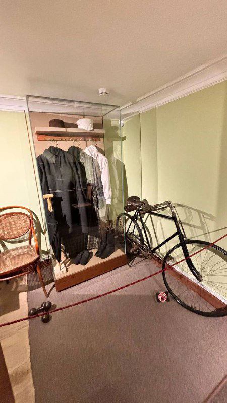 Уголок гардероба в музее Толстого: крючки с одеждой, старый велосипед и бытовые детали, вписанные в экспозицию дома.