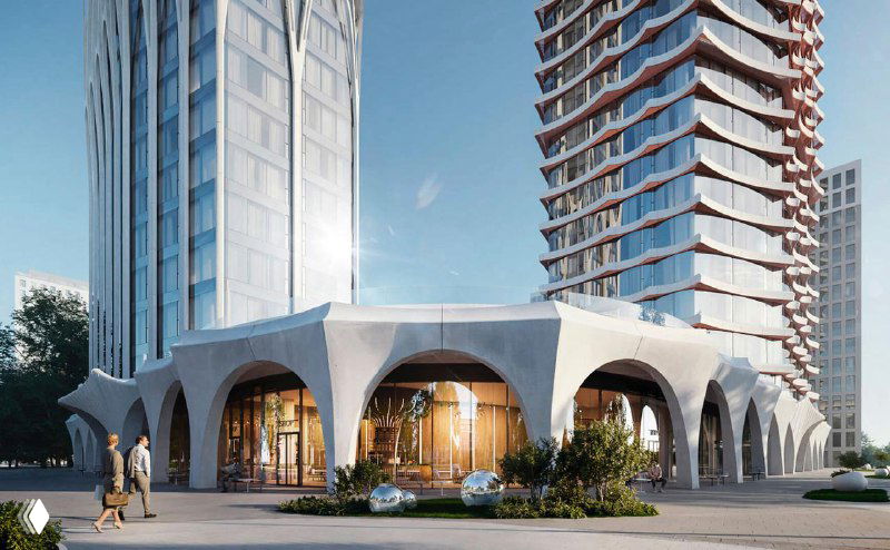 Фрагмент стилобата ЖК A22: крупный план входной группы, колоннада и коммерческие помещения на уровне улицы рядом с озеленением.