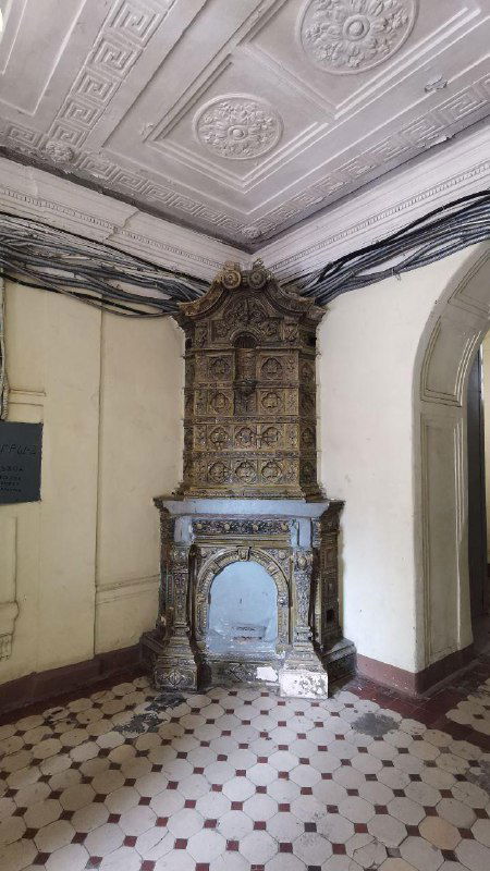 Старинная каминоподобная печь и лепнина в парадной доходного дома Петербурга: детали интерьера XIX–XX вв., сохранившиеся до нашего времени.