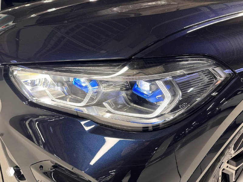 Крупный план лазерной оптики BMW X5 30d xDrive MSport: детализированный вид световых модулей и элементов фар на чёрном кузове.
