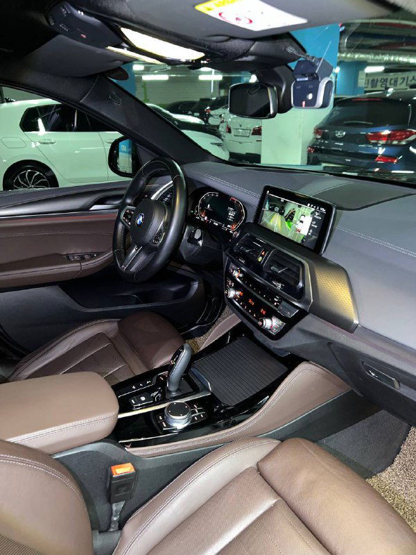 Общий вид передней части салона BMW X4: водительское и пассажирское места, рычаг коробки, центральный подлокотник и состояние интерьера в целом.