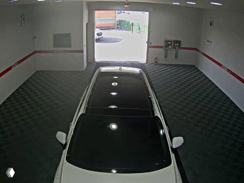 Крыша белого Hyundai Santa Fe с панорамной чёрной вставкой, съёмка сверху в помещении для осмотра, видна антенна и элементы крыши