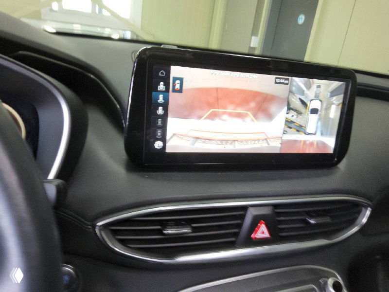Мультимедийный экран на центральной консоли Hyundai Santa Fe, отображается изображение с камеры и панорамный обзор вокруг автомобиля