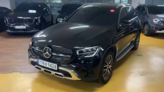 Крупный план черного Mercedes GLC 220 D 4Matic слева‑спереди, демонстрация внешнего состояния кузова и дисков колёс в паркинге.