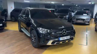 Повторный ракурс черного Mercedes GLC 220 D 4Matic в паркинге — вид спереди‑лево, демонстрация общей геометрии автомобиля и состояния кузова.