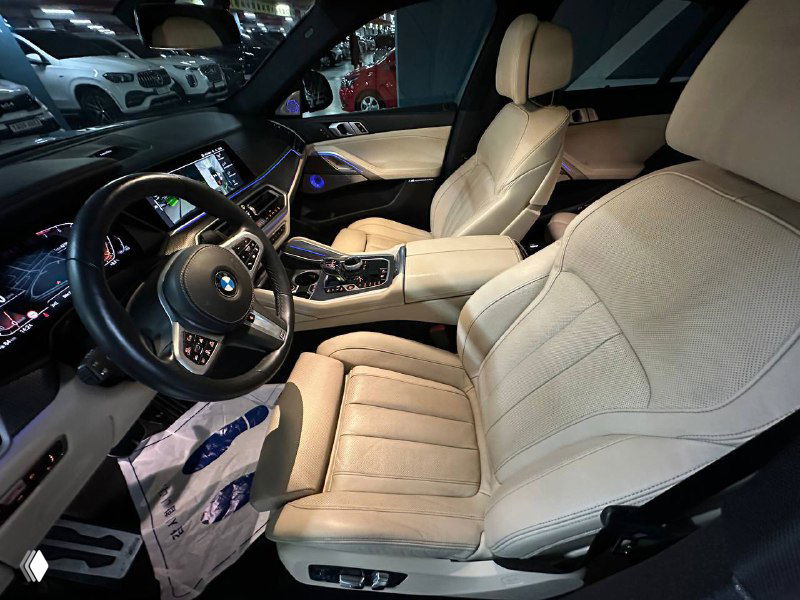 Светлый кожаный салон BMW X6 в передней части: водительское и пассажирское кресла, центральная консоль и элементы отделки видны в анфас