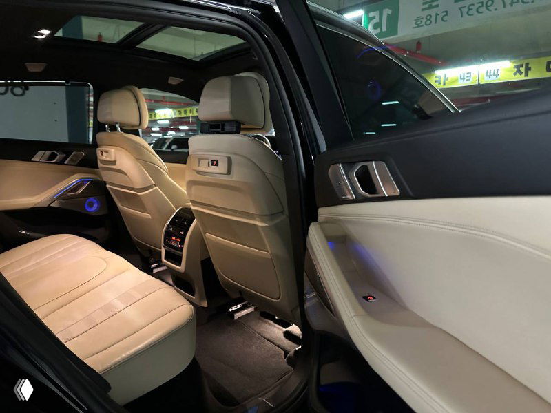 Открытая дверь BMW X6 с видом на отделку дверной карты, подсветку и декоративные вставки — детали салона и качество материалов хорошо видны