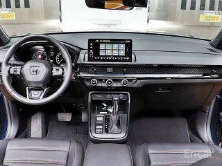 Панель приборов и центральный дисплей Honda CR‑V Touring: мультимедиа экран, руль и элементы управления климатом в салоне.