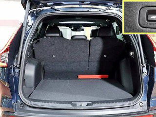 Багажное отделение Honda CR‑V Touring с поднятой дверью: ровный пол, отсеки по бокам и опция складных спинок заднего ряда.