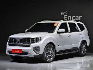 Kia Mohave Masters белого цвета, угол спереди справа на тёмном фоне, демонстрация боковой линии кузова, защитных накладок и фар головного света.