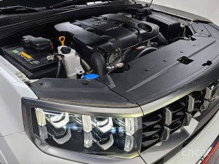 Подкапотный отсек Kia Mohave Masters с видимым дизельным двигателем 3.0, аккумулятором и другими техническими узлами, чистый и ухоженный моторный отсек.