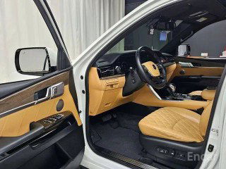 Открытая дверь водителя Kia Mohave Masters, вид на переднее сиденье, торпедо и двери с деревянными вставками и элементами управления стеклоподъёмниками.