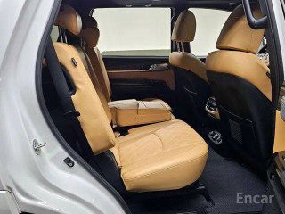 Задний ряд сидений Kia Mohave Masters с коричневой кожаной обивкой, показан простор для пассажиров второго ряда и состояние обивки и подлокотника.