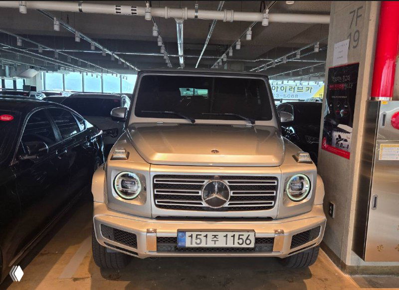 Ещё один вид спереди Mercedes G‑VAGEN 400D на парковочном месте, видна стойка автомобиля и парковочные места вокруг