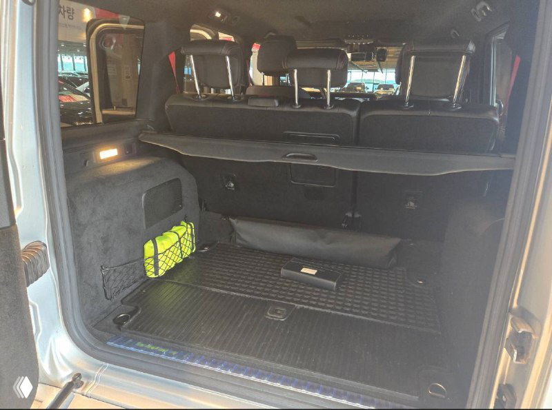 Багажный отсек Mercedes G‑VAGEN: открытая грузовая зона с резиновым ковриком и отсеком для аварийного набора внизу