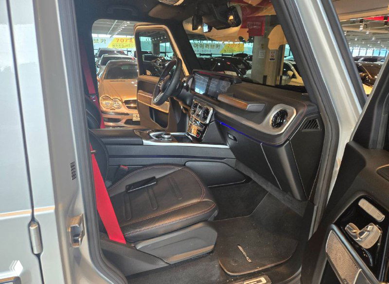 Вид на переднее пассажирское место и центральную консоль Mercedes G‑Class: кожа, подсветка, элементы управления и комфортная посадка