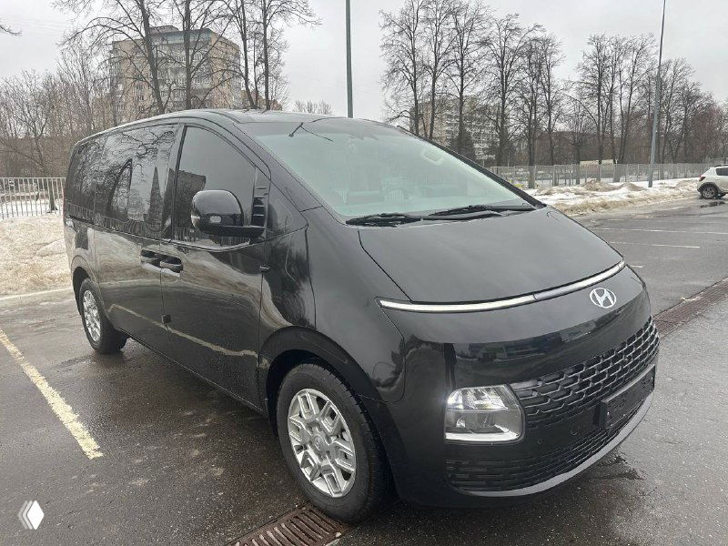Ещё один перспективный трёхчетвертной ракурс чёрного Hyundai Staria Cargo с акцентом на переднюю часть и боковую линию кузова.