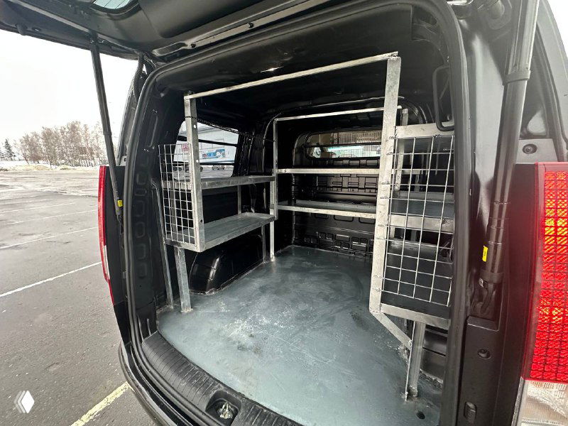 Грузовой отсек Hyundai Staria Cargo оборудован стеллажами и перегородками для коммерческого использования; показано внутреннее пространство багажника.