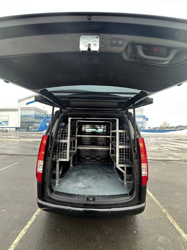 Вид из задней части в открытый багажник Hyundai Staria Cargo с установленными полками и металлическими ограждениями для грузов, рабочее покрытие пола.