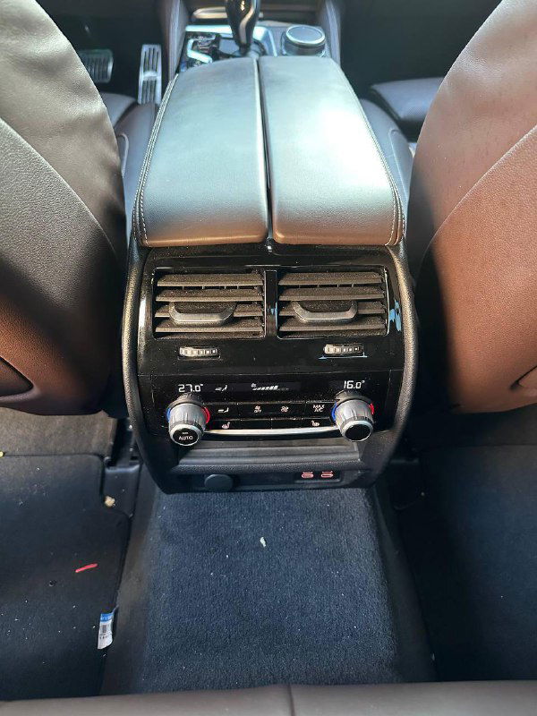 Задняя часть центральной консоли с вентиляционными решётками и органами управления климата для задних пассажиров, фотография салона.