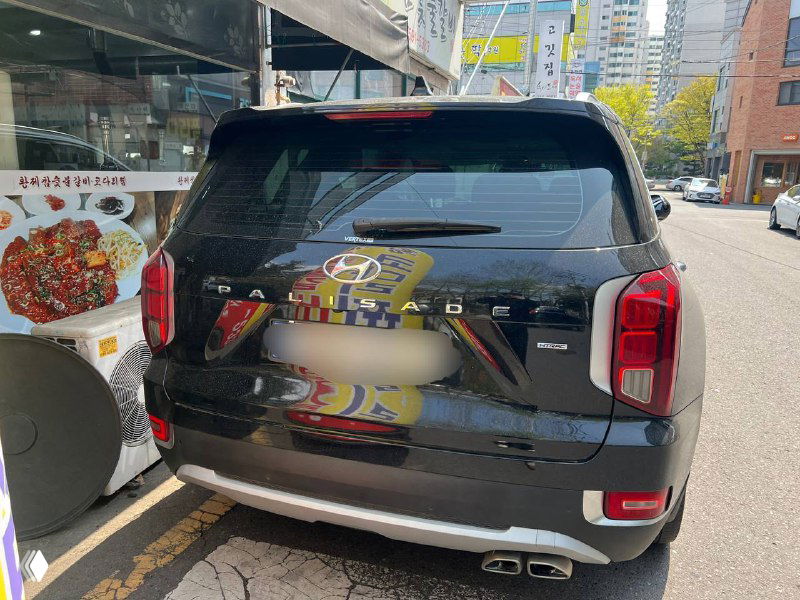 Задняя часть Hyundai Palisade Prestige: багажник и фонари, видно фирменные элементы дизайна и эмблема модели на двери багажника.