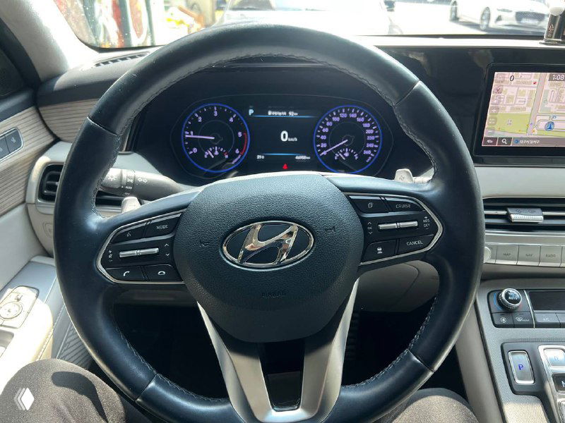 Руль и панель приборов Hyundai Palisade Prestige: мультифункциональный руль с логотипом Hyundai и часть приборной панели на переднем плане.