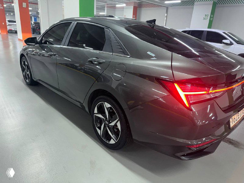 Hyundai Avante — задняя трёхчетвертная проекция автомобиля в подземном паркинге, видно задние фонари и форму багажной крышки.