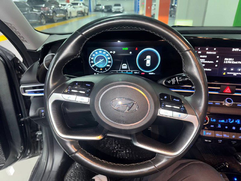 Салон Hyundai Avante: обзор руля и цифровой приборной панели с включённой подсветкой, состояние руля и приборов видно на фото.