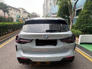 Вид сзади BMW X3 20i xDrive M Sport Pro, белый кузов, задние фонари и часть номерного знака закрыты; фото показывает багажную часть и бампер.